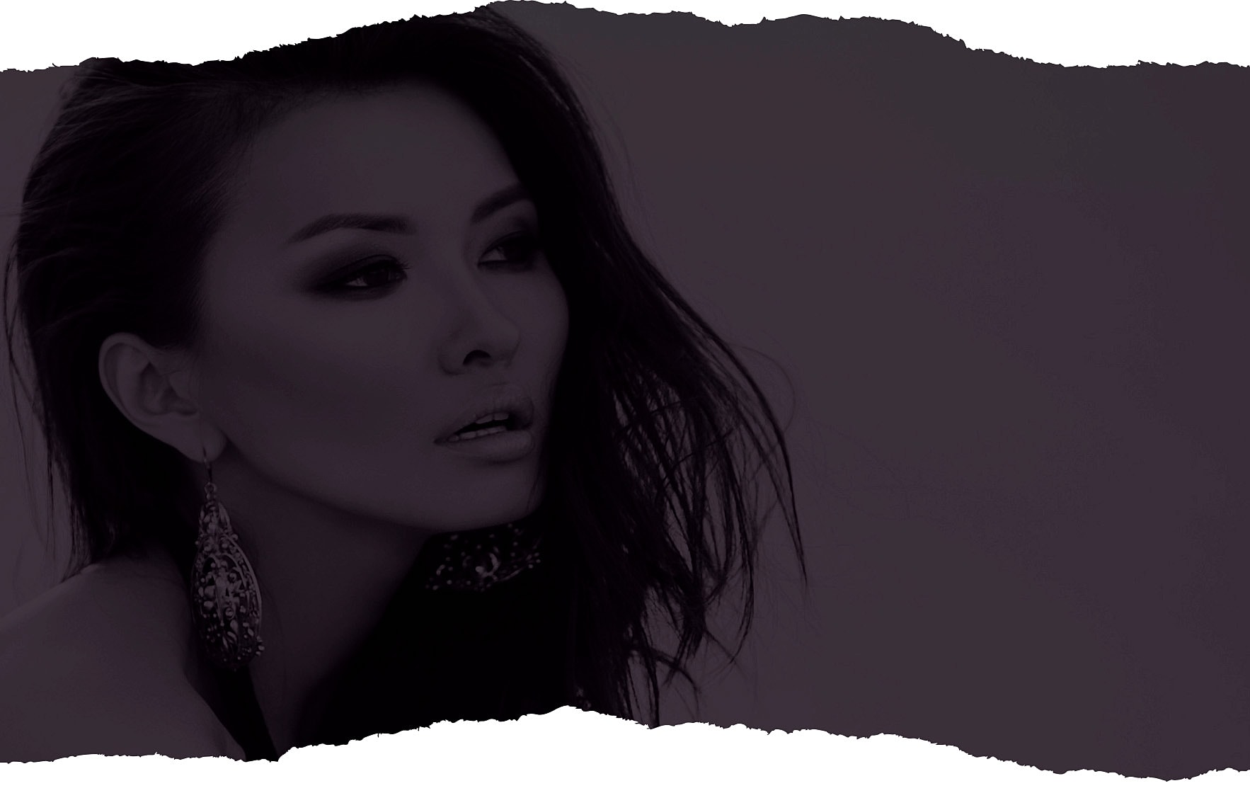 Portrait of a woman with dramatic makeup and earrings.