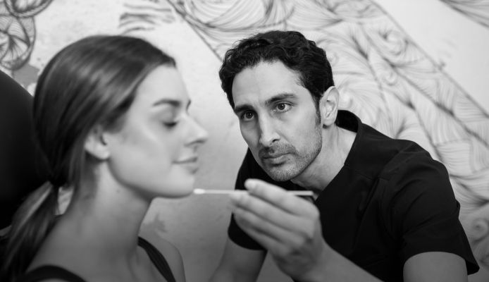Professional applying treatment to woman's face.