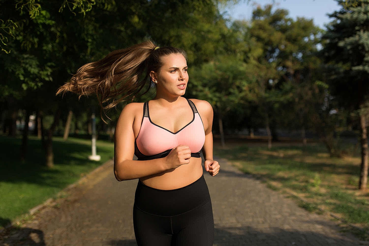 Woman jogging in a park on a sunny day.