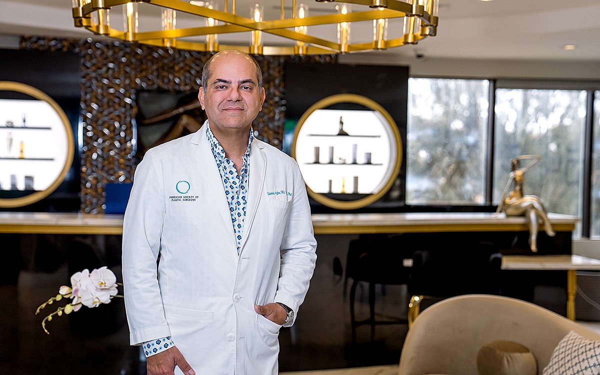 Doctor Siamak Agha at his clinic wearing a white coat.