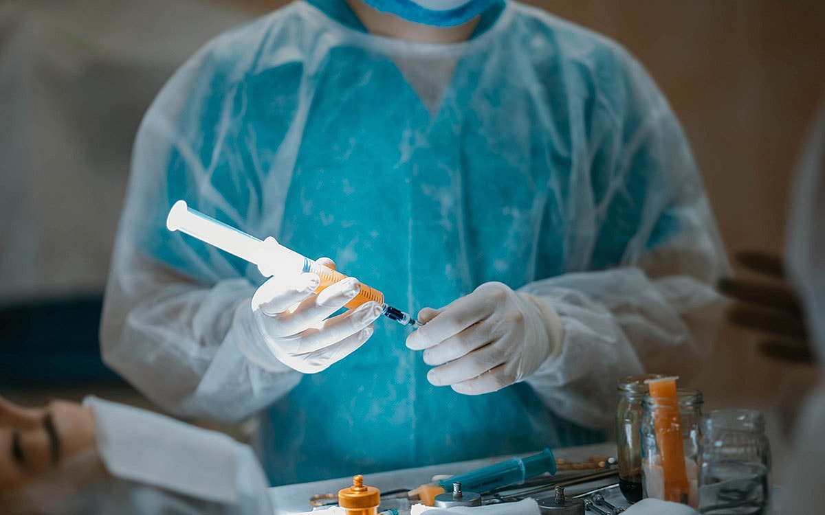 doctor pumping and filtering fat in syringes.