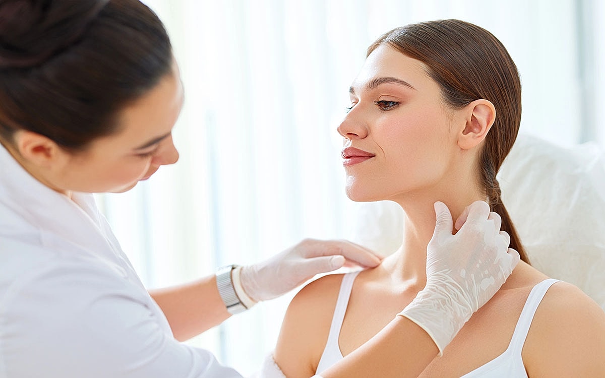 Woman consultation for neck lift treatment in clinic.