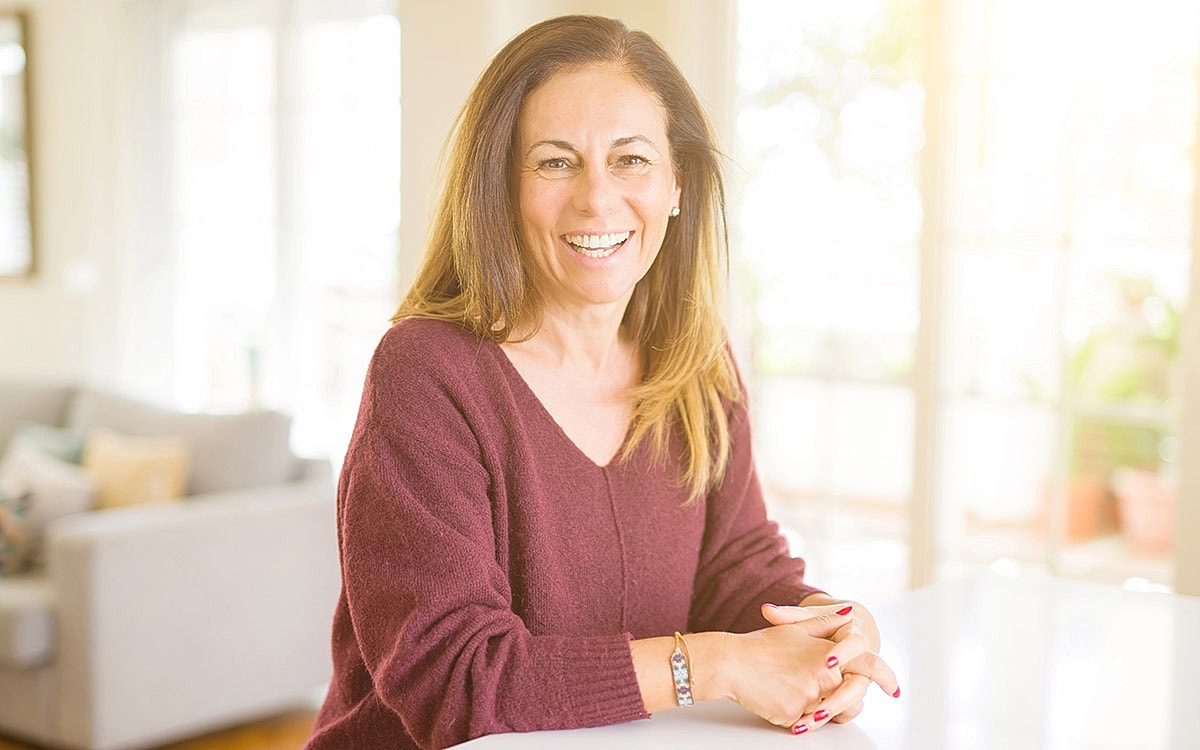 Smiling woman in a cozy indoor setting.